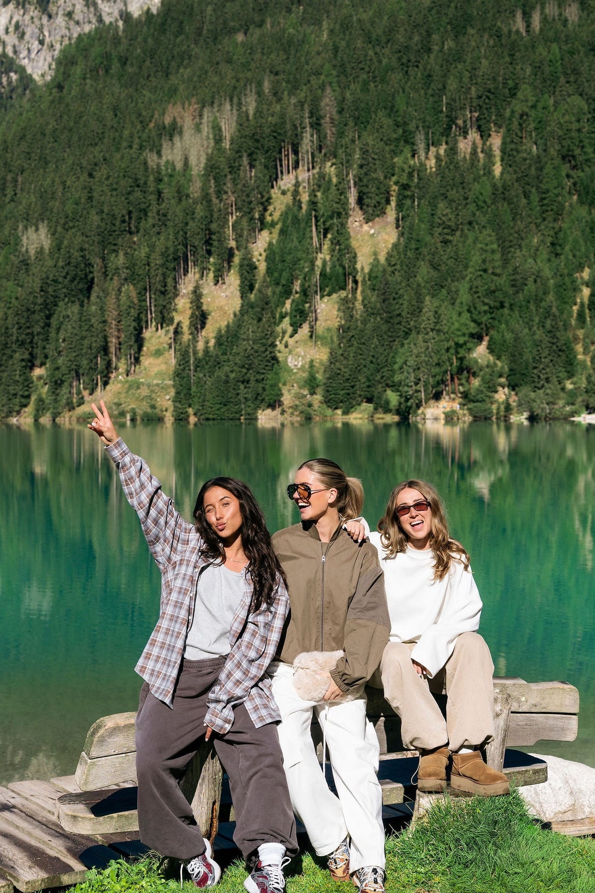 Three friends on a bench by a lake in the Dolomites