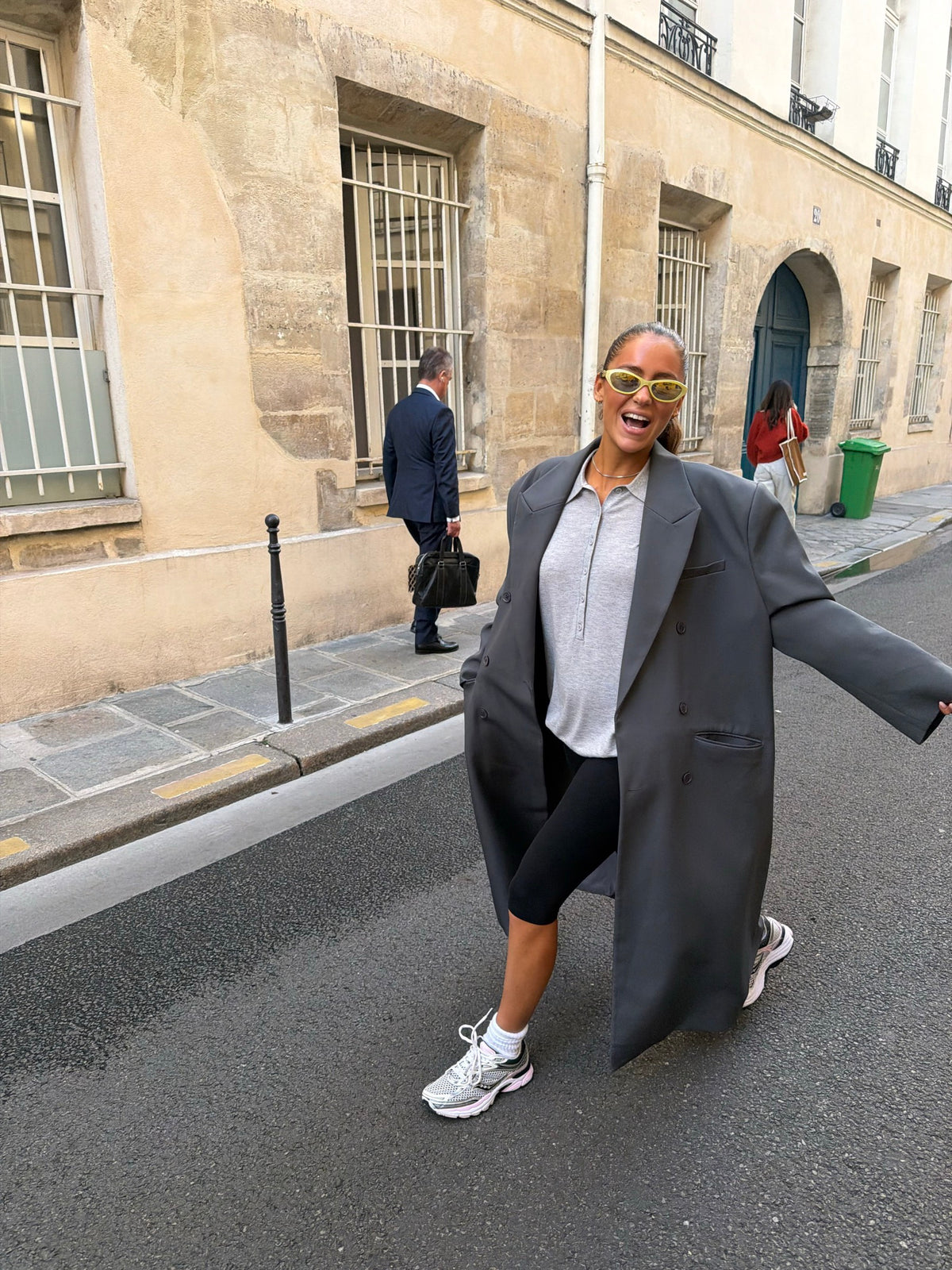 Laughing in a long grey coat on the street